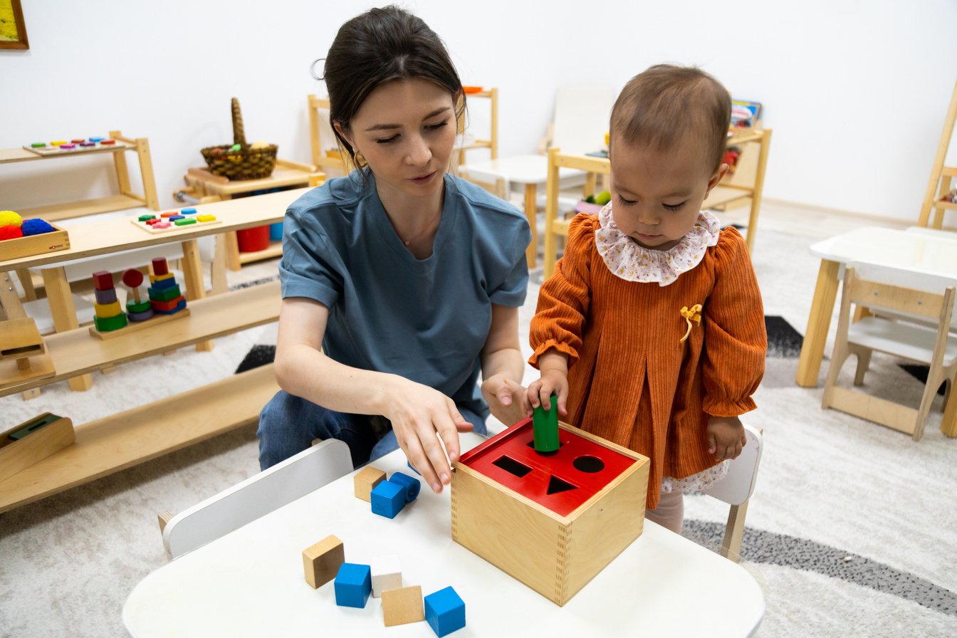 Toddler playing with montessori Imbucare shapes box